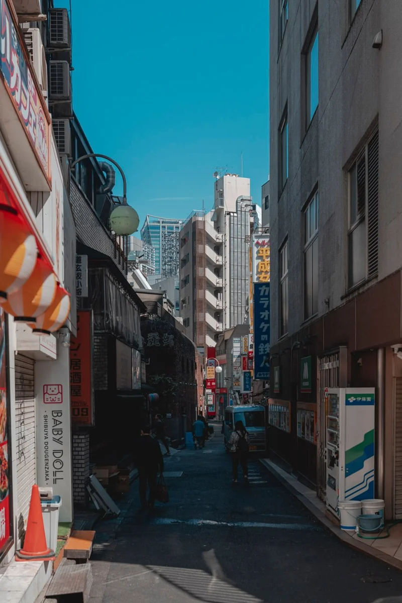 A city street with a bright blue accent among signs and buildings.